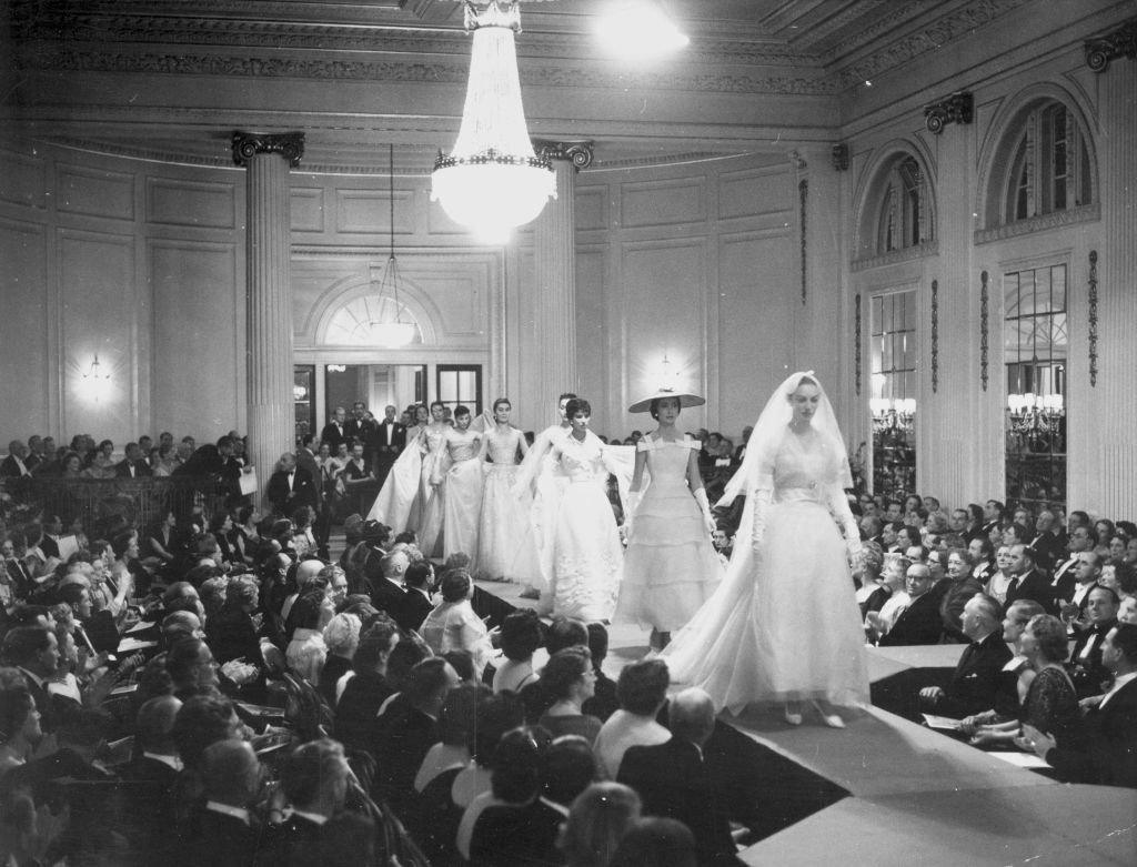 Mannequins walking down the 64 foot catwalk during the grand finale of Christian Dior's 1955 fashion show at a ball in Gleneagles.