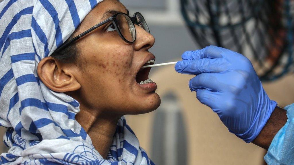 A swab sample is collected from a woman in Mumbai.