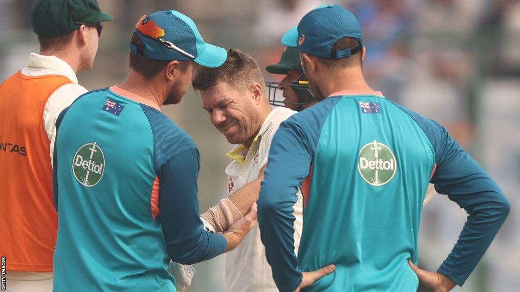 David Warner receives treatment for an elbow injury