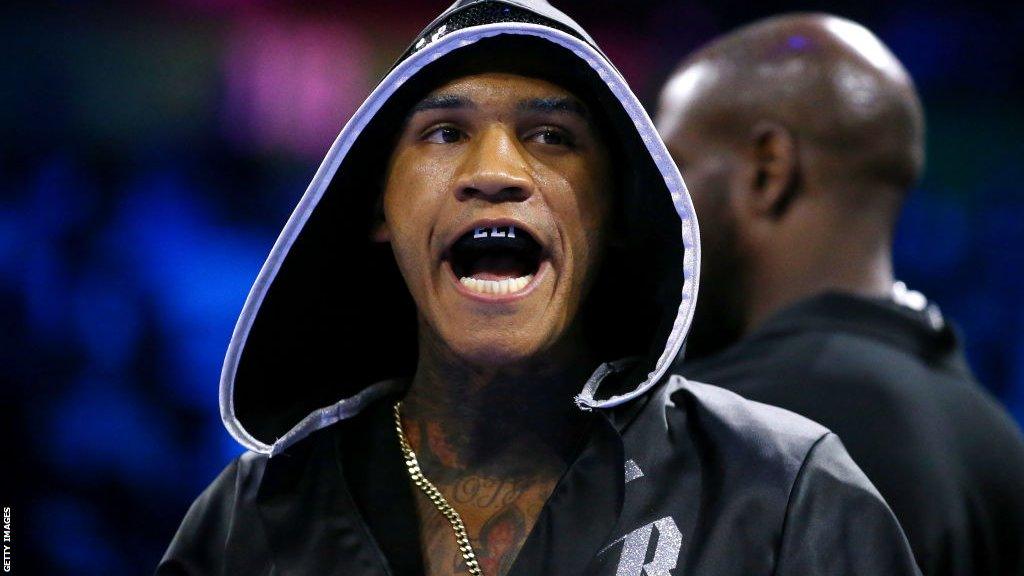 Conor Benn with a black mouthguard in his mouth and black hood