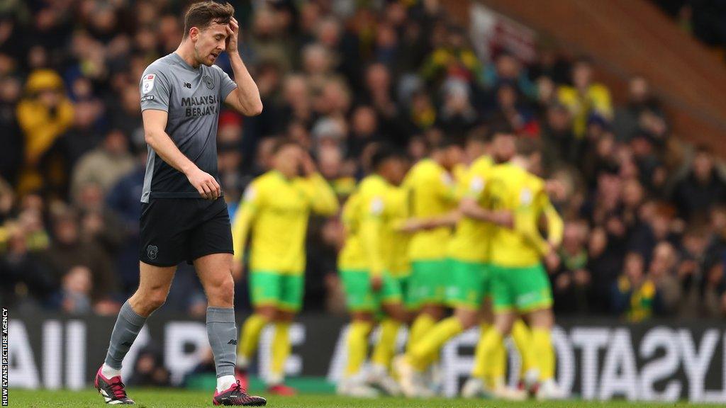 Norwich celebrate their opening goal as Perry Ng looks on