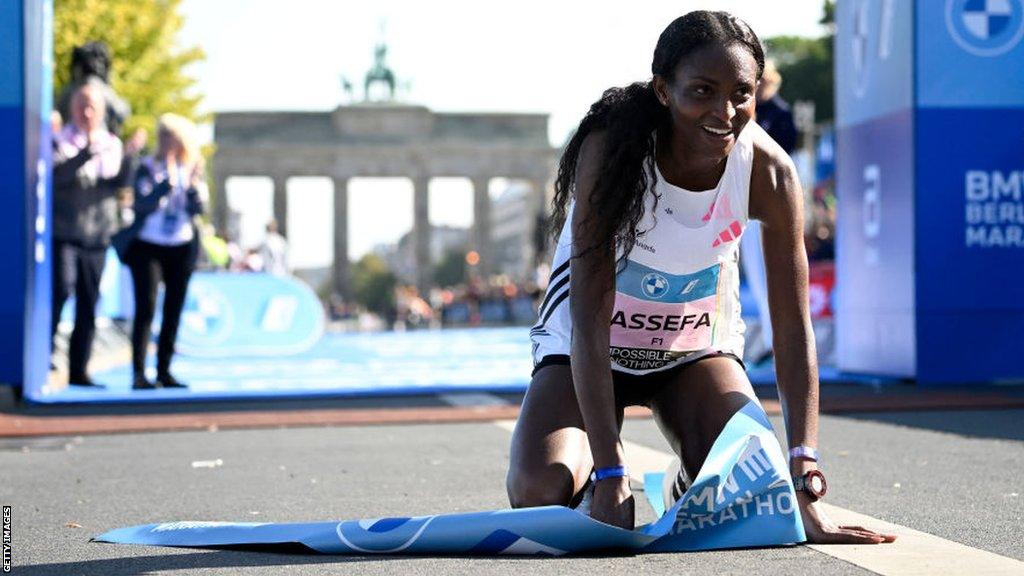 Tigst Assefa kneels down after smashing the women's marathon world record in Berlin