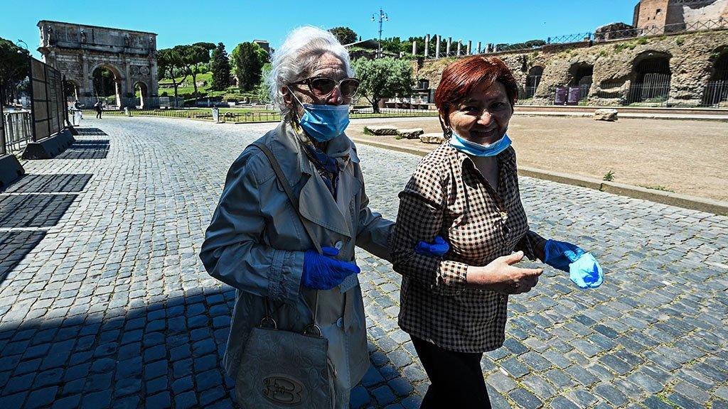 An elderly woman accompanied walking in Rome