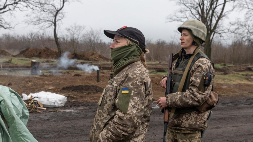 Ukrainian soldiers stand at their position outside the village of Barvinkove, Kharkiv region