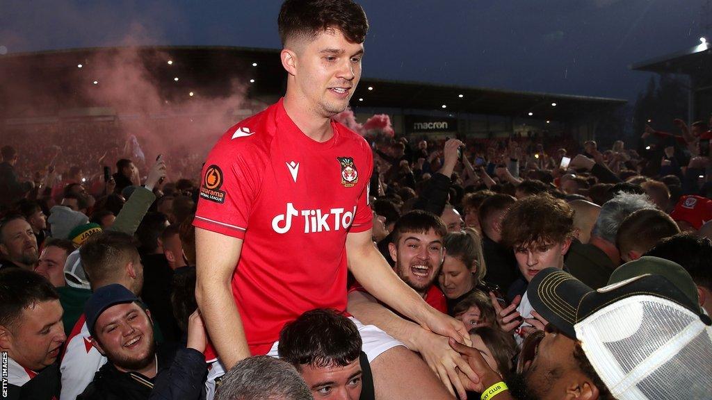 Supporters carry Wrexham-born Jordan Davies on their shoulders as they celebrate promotion