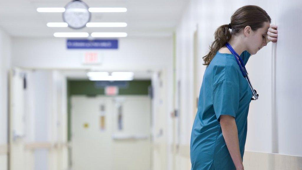 Medical worker leaning head on wall