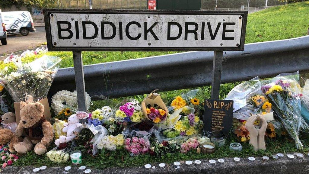 Flowers lay next to Biddick Drive sign