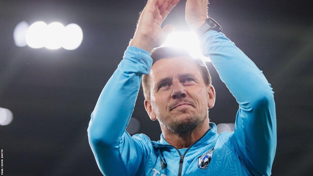 Manager Tony Pennock applauds the fans at Cardiff City Stadium.