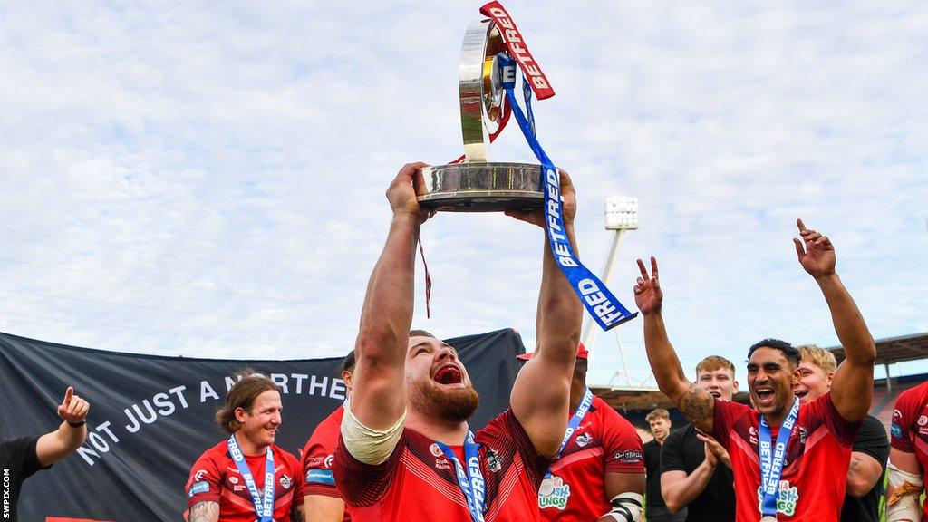 London Broncos hooker Sam Davis lifts a trophy