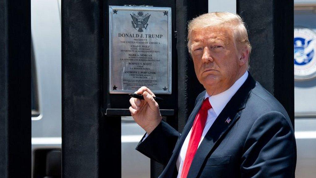 President Trump inspects a section of wall with a signed plaque on it