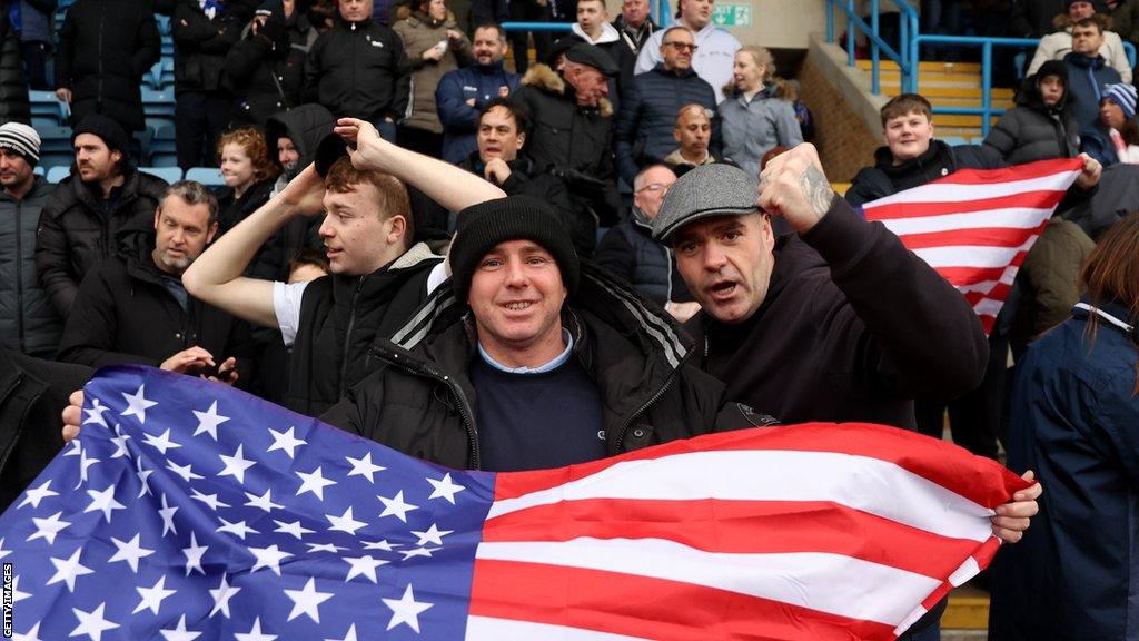 Gillingham fans pose with an American flag