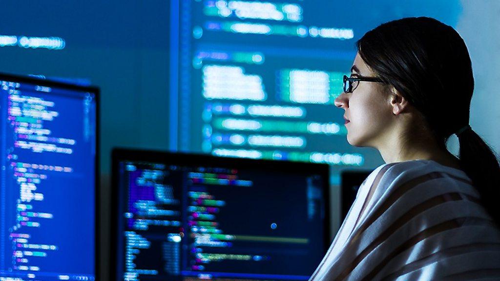 woman looking at computer monitors