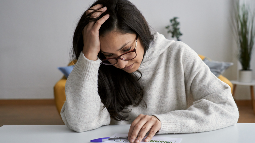 A woman looks at a bill