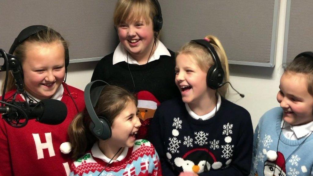 image of kids in christmas jumpers singing