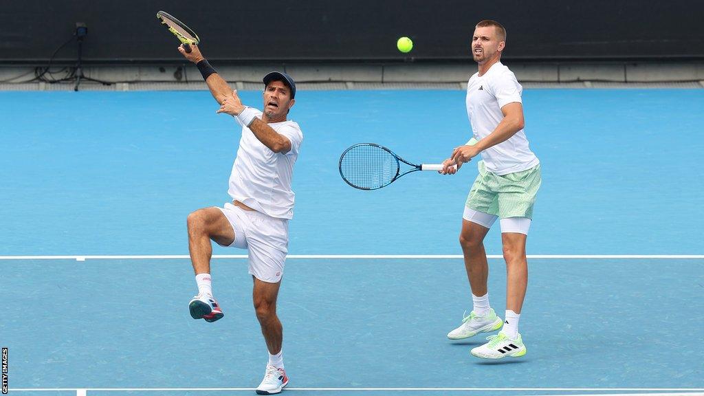 Jean-Julien Rojer of the Netherlands plays a forehand in his round two doubles match with Lloyd Glasspool of Great Britain