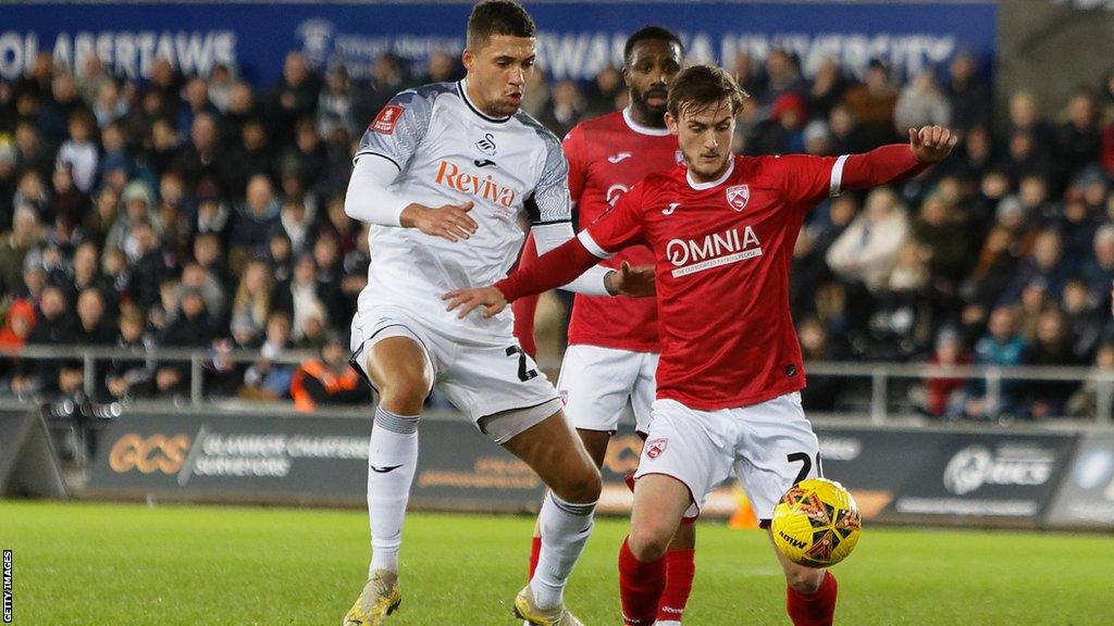 Nathan Wood of Swansea City challenges Charlie Brown of Morecambe during the Emirates FA Cup Third Round match between Swansea City and Morecambe at the Swansea.com Stadium on January 06, 2024 in Swansea, Wales. (