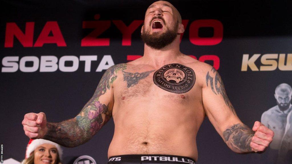 Phil De Fries shouts and flexes at a weigh-in