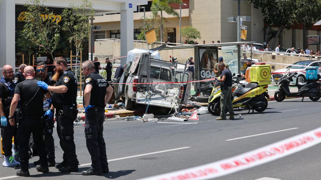 Members of Israeli security and emergency personnel work at the site of a reported car ramming attack in Tel Aviv