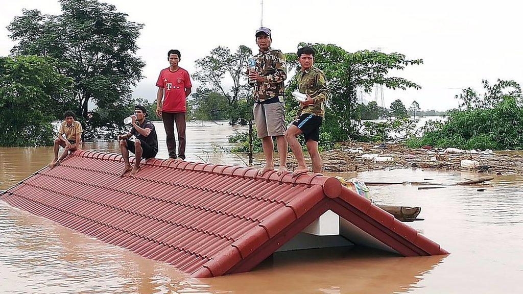 Laos villagers are stranded on a roof of a house.