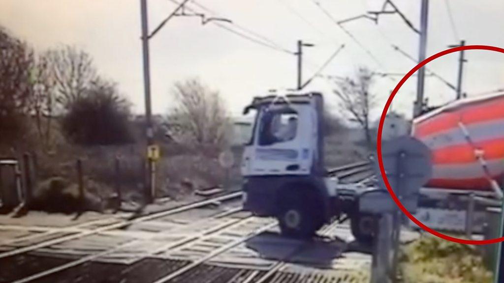 Railway crossing barrier closing on lorry