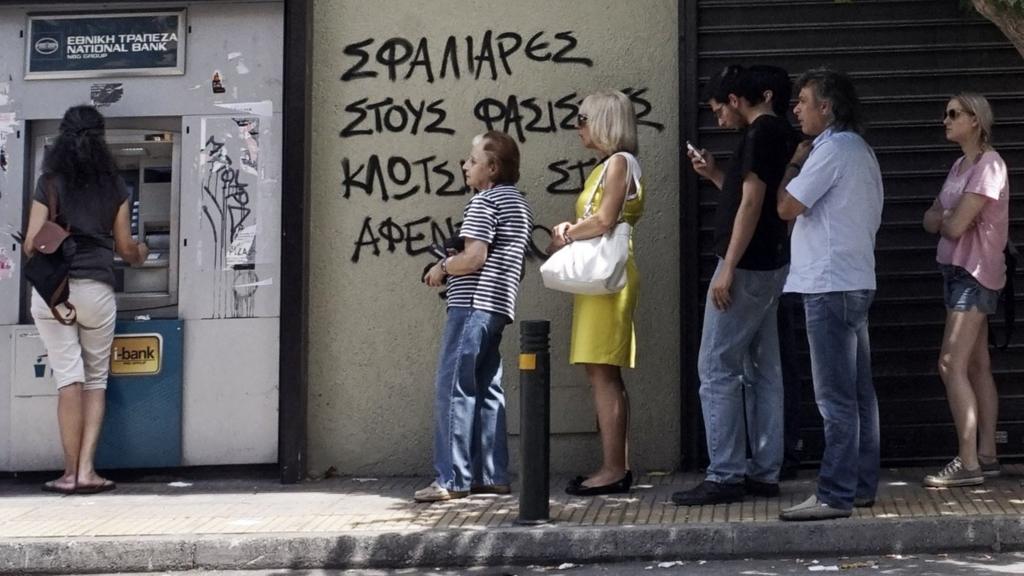 People queue at a cash machine in Athens, 27 June