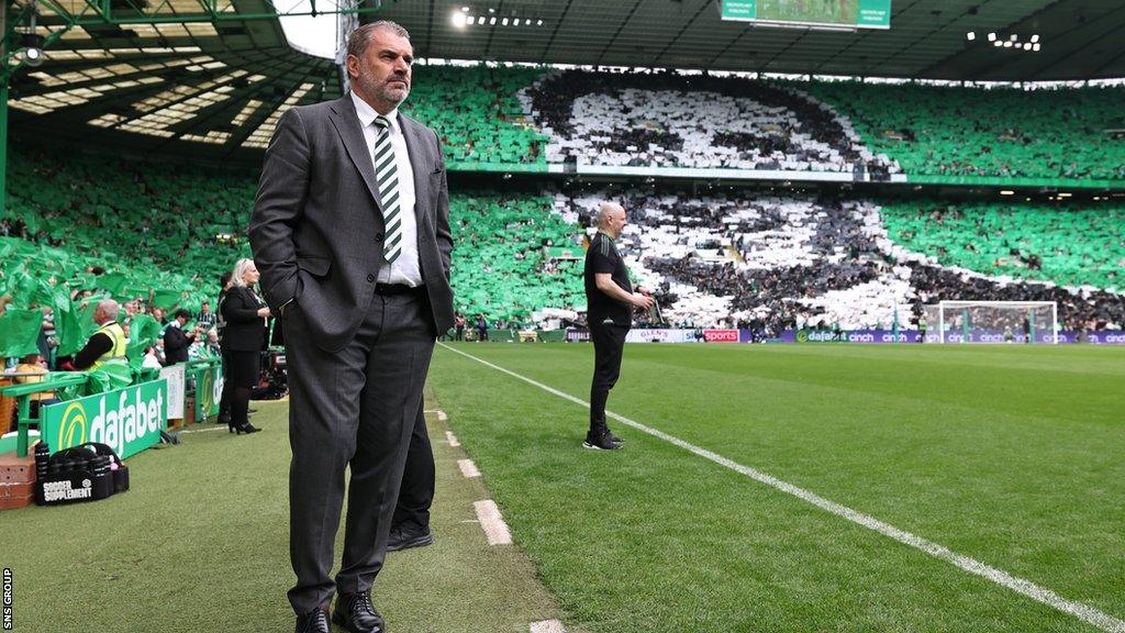 Celtic Manager Ange Postecoglou watches as fans display a tifo in honour of him during a cinch Premiership match between Celtic and Aberdeen at Celtic Park