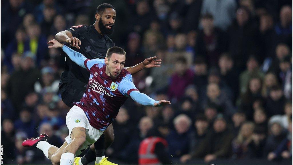 Burnley's Darko Churlinov is challenged for the ball by Janoi Donacien in an FA Cup match against Ipswich