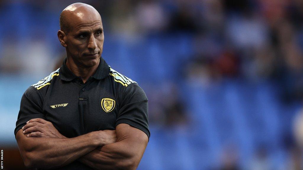 Burton Albion boss Dino Maamria watches his side with his arms crossed