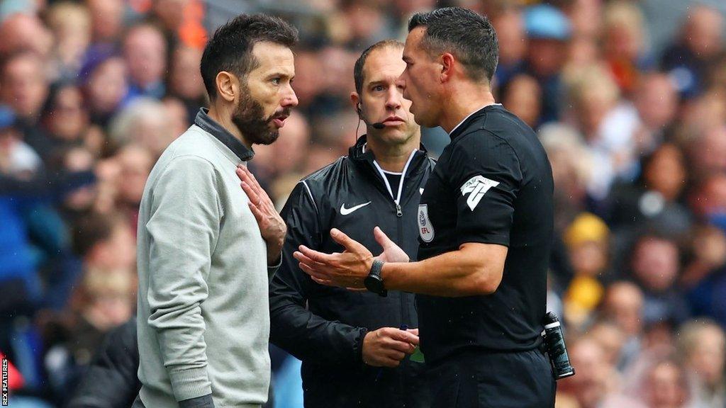 Referee Dean Whitestone speaks to West Brom boss Carlos Corberan