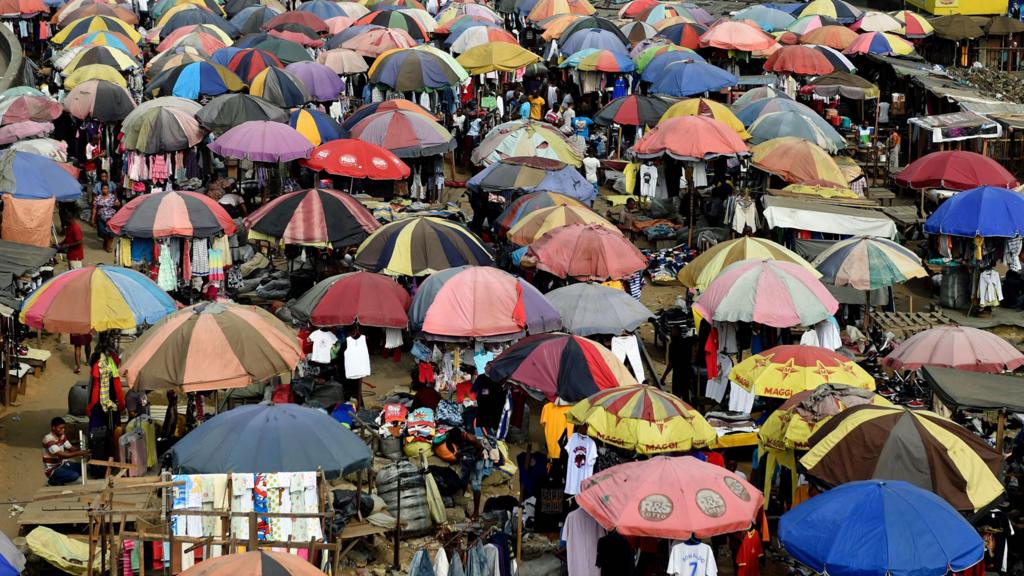 Traders cover their wares with umbrellas of different shapes and sizes along the railway line in Port Harcourt, Nigeria - February 2017