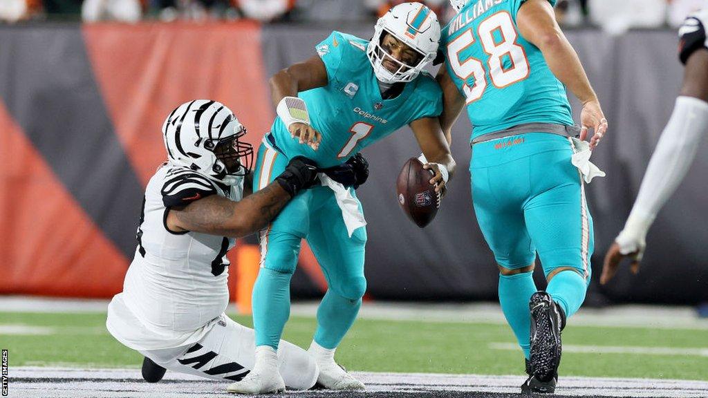 Tua Tagovailoa being tackled by Josh Tupou of the Cincinnati Bengals