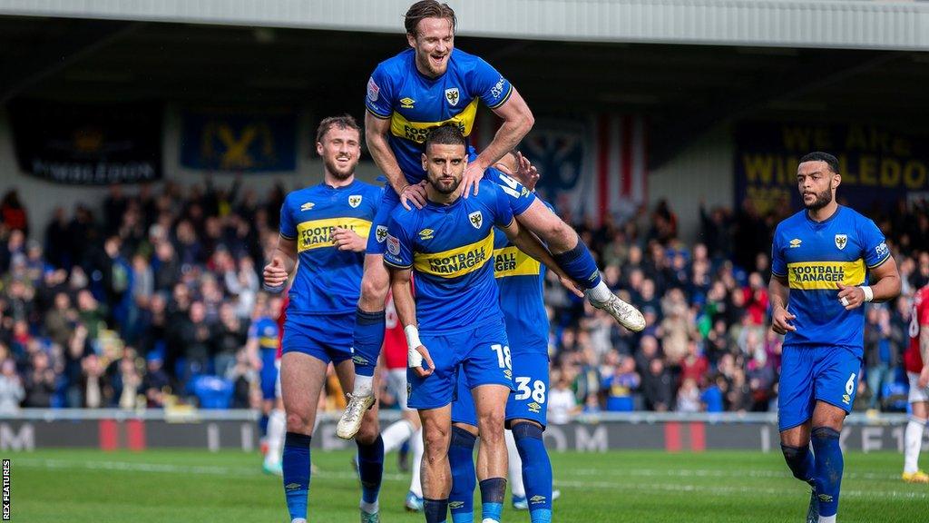 Wimbledon players celebrate Omar Bugiel's goal