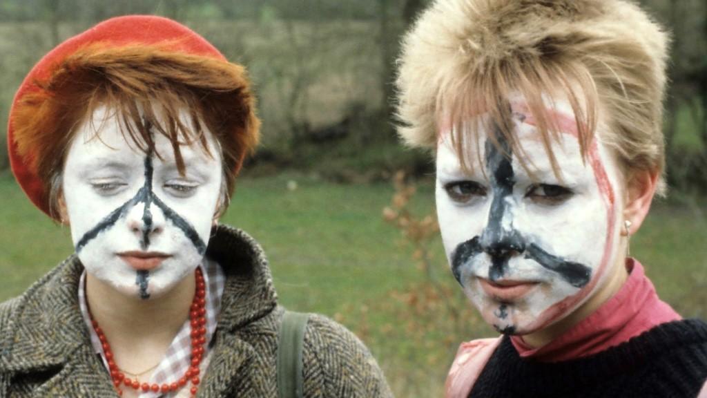 Two women with peace signs painted on their face