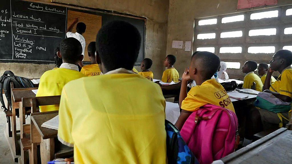 Pupils and a teacher in a schoolroom in Ghana