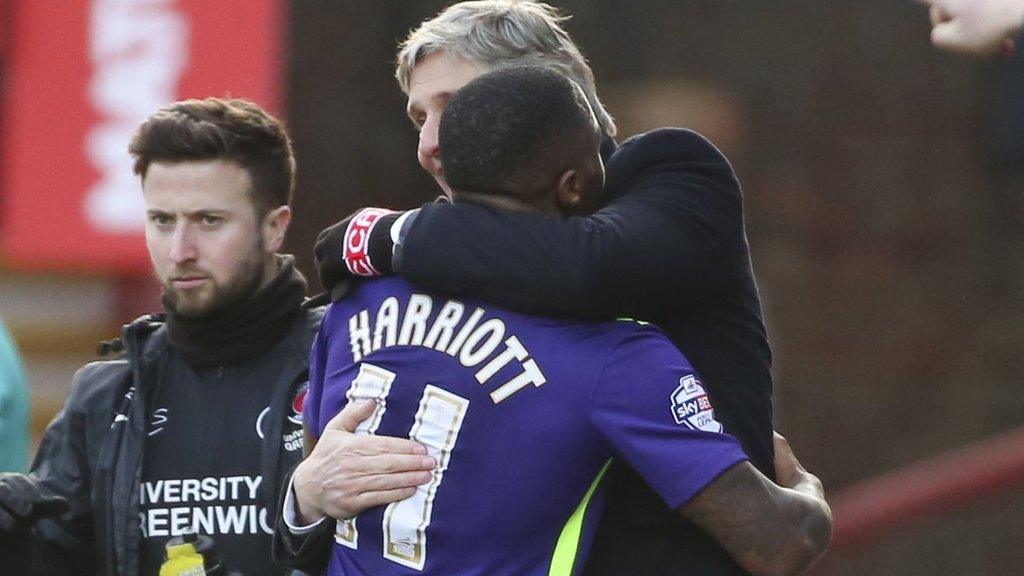 Callum Harriott is hugged by his manager Jose Riga after scoring at Griffin Park