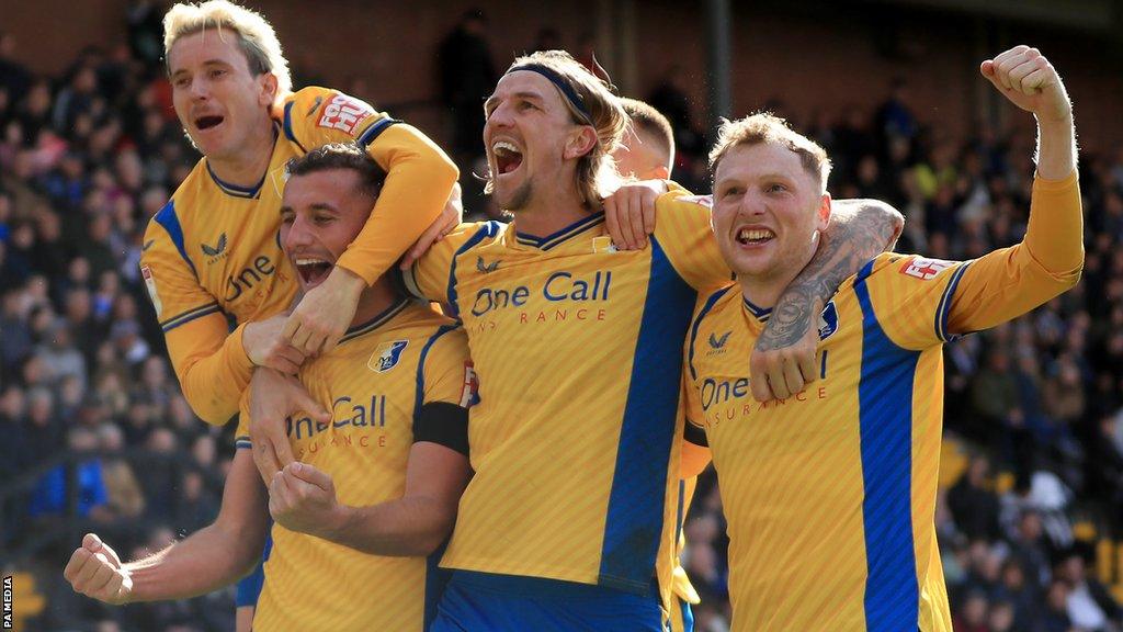 Mansfield Town players celebrate against Notts County