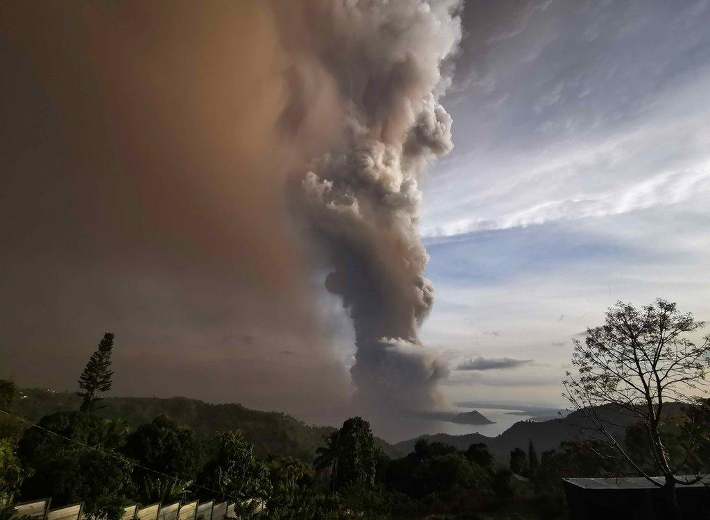 An ash column from erupting Taal Volcano looms over Tagaytay city, Philippines, 12 January