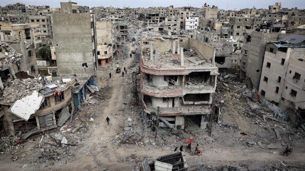 People and damaged buildings in Khan Younis on 8 April