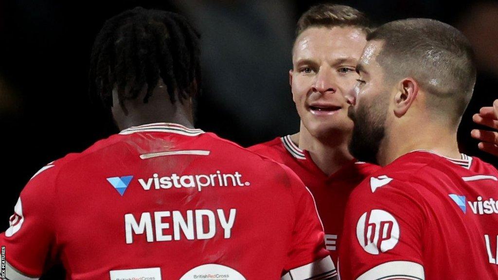 Jacob Mendy (L) and Paul Mullin (C) celebrate