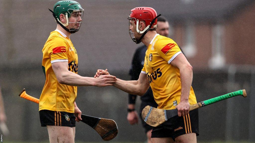 Antrim players Conal Cunning and Eoin O'Neill shake hands after the final whistle at Corrigan Park