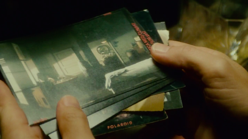 Deckard flicks through a set of Polaroid photographs