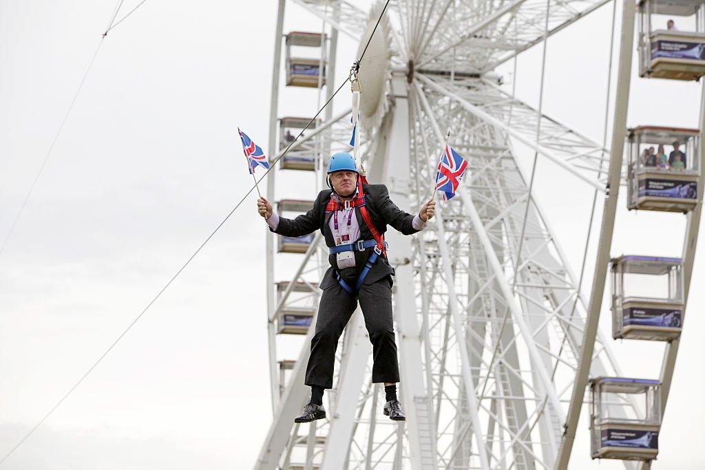 London Mayor Boris Johnson as he is left hanging in mid-air after he got stuck on a zipwire at an Olympic event at Victoria Park in the capital