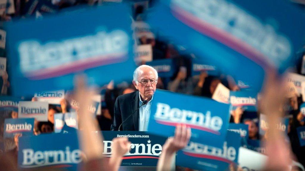 Bernie Sanders surrounded by posters and supporters