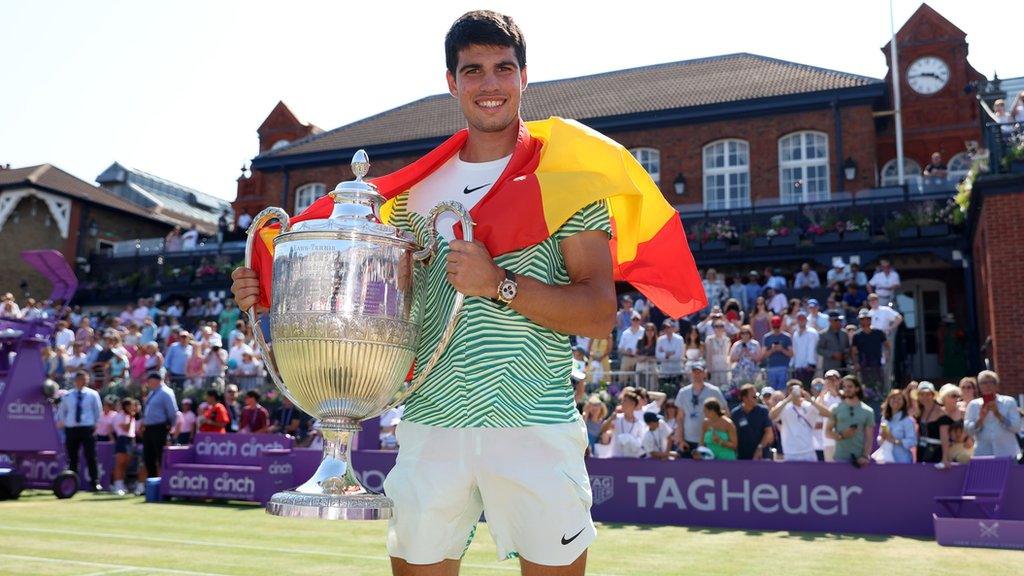 Carlos Alcaraz holds the Queen's trophy
