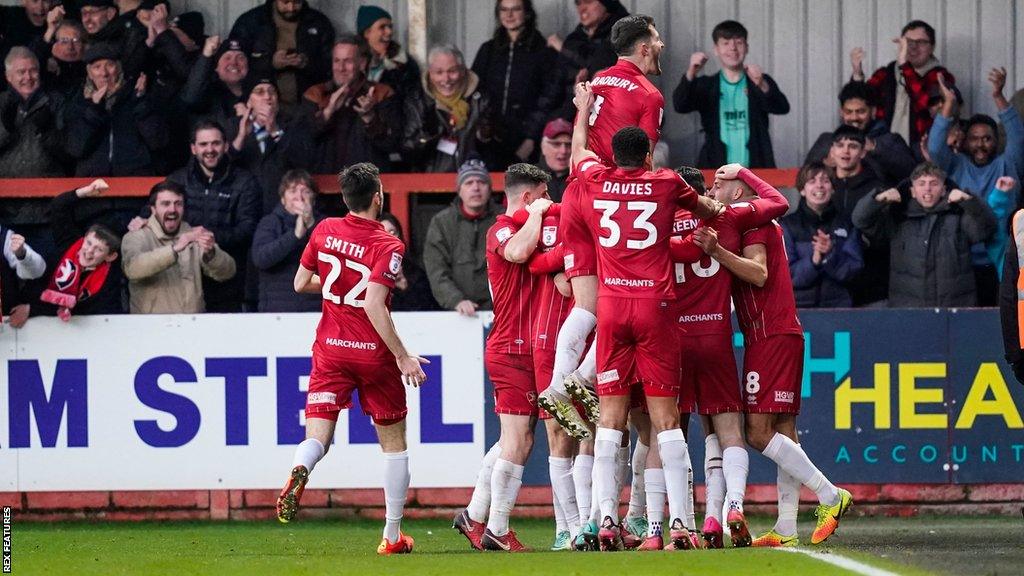 Cheltenham players celebrate a goal against Portsmouth