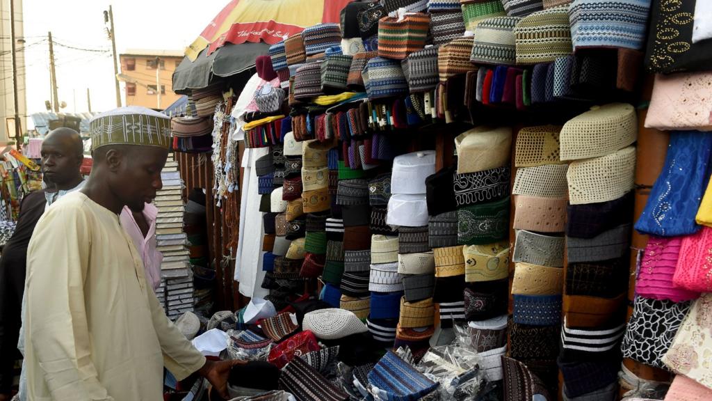 A man looks at various Taqiyah caps on sale in Lagos, on 26, 2017, as Muslims begin with preparations to mark the holy fasting month of Ramadan