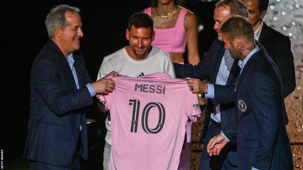 Lionel Messi holding an Inter Miami shirt