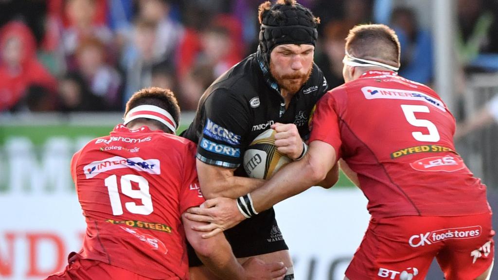 Glasgow Warriors' Tim Swinson makes is tackled by Scarlets' Steven Cummins (right) and Lewis Rawlins