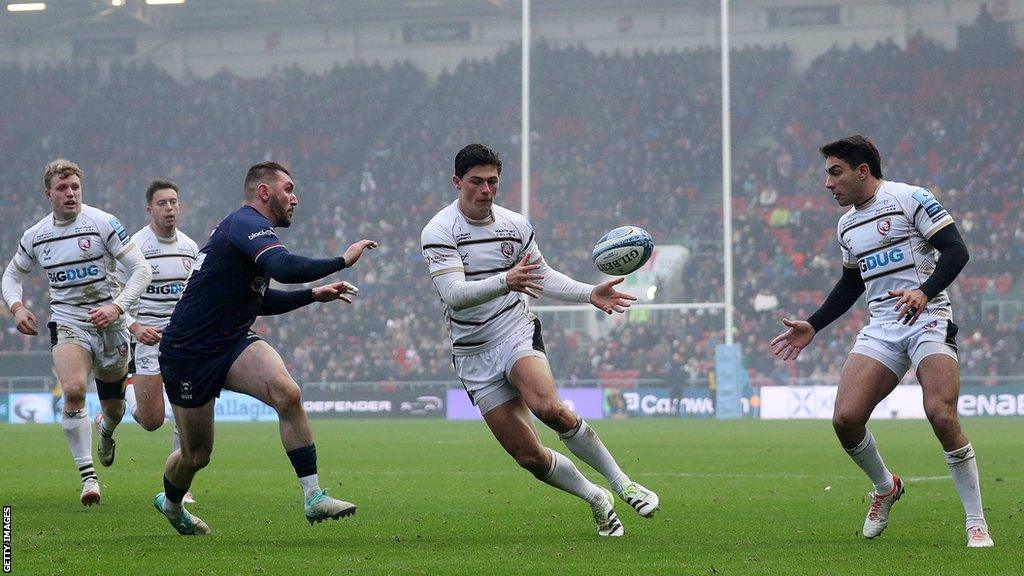 Louis Rees-Zammit (centre) passes the ball to team-mate Santiago Carreras