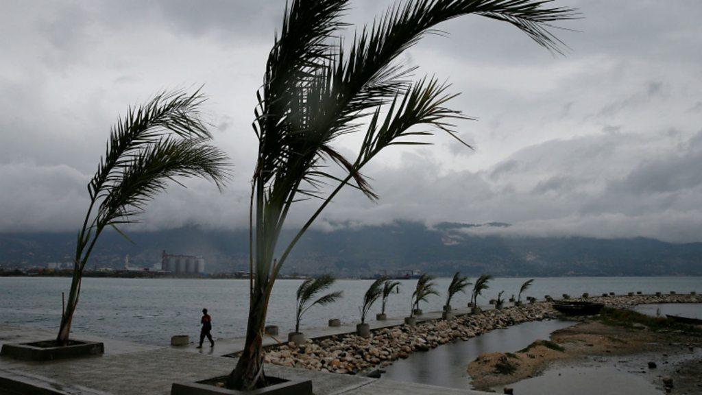 Man on a pier in Port-au-Prince with Hurricane Matthew approaches